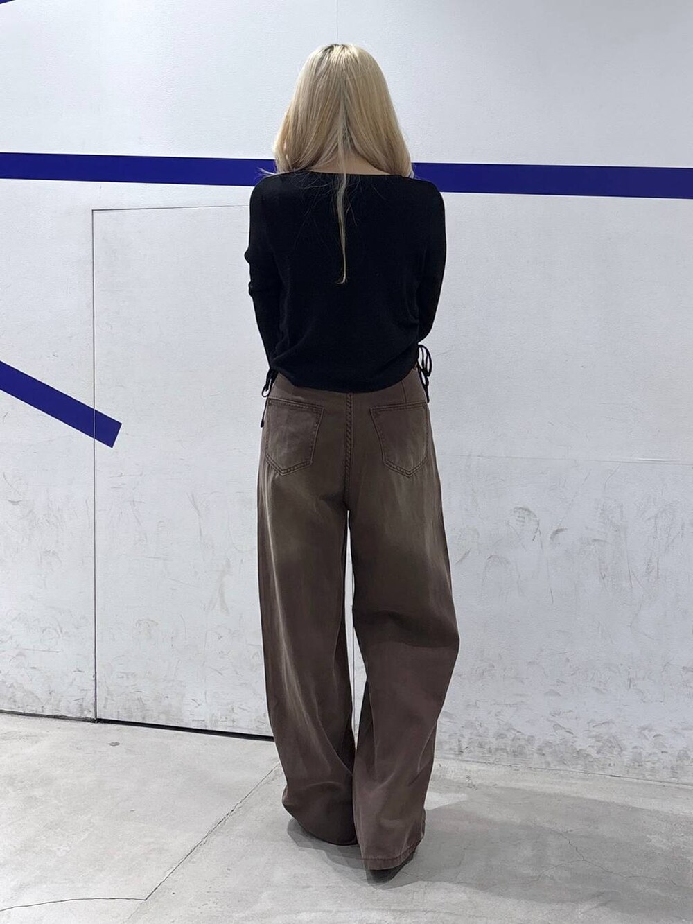 ブラウン系のデニムパンツ、ブラック系のTシャツ/カットソーを着用したレディースの秋コーディネートの4枚目の写真