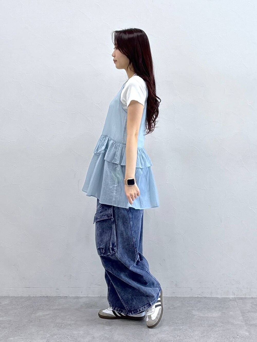 パープル系のカーゴパンツ、ブルー系のワンピース、ベージュ系のTシャツ/カットソーを着用したレディースの春コーディネートの3枚目の写真
