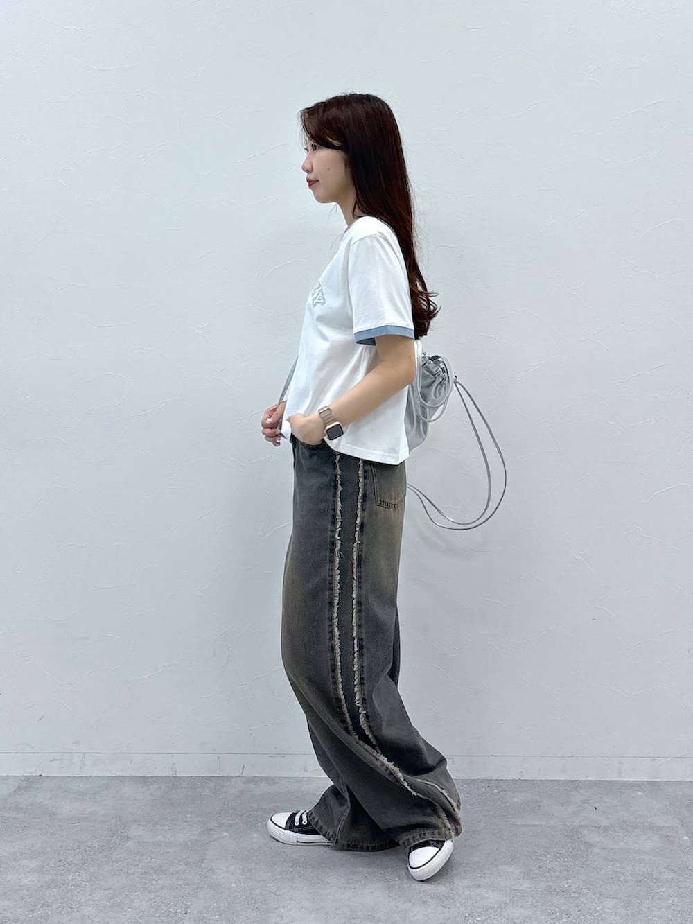 ブルー系のデニムパンツ、ホワイト系のTシャツ/カットソー、グレー系のバックパック/リュックを着用したレディースの夏コーディネートの3枚目の写真
