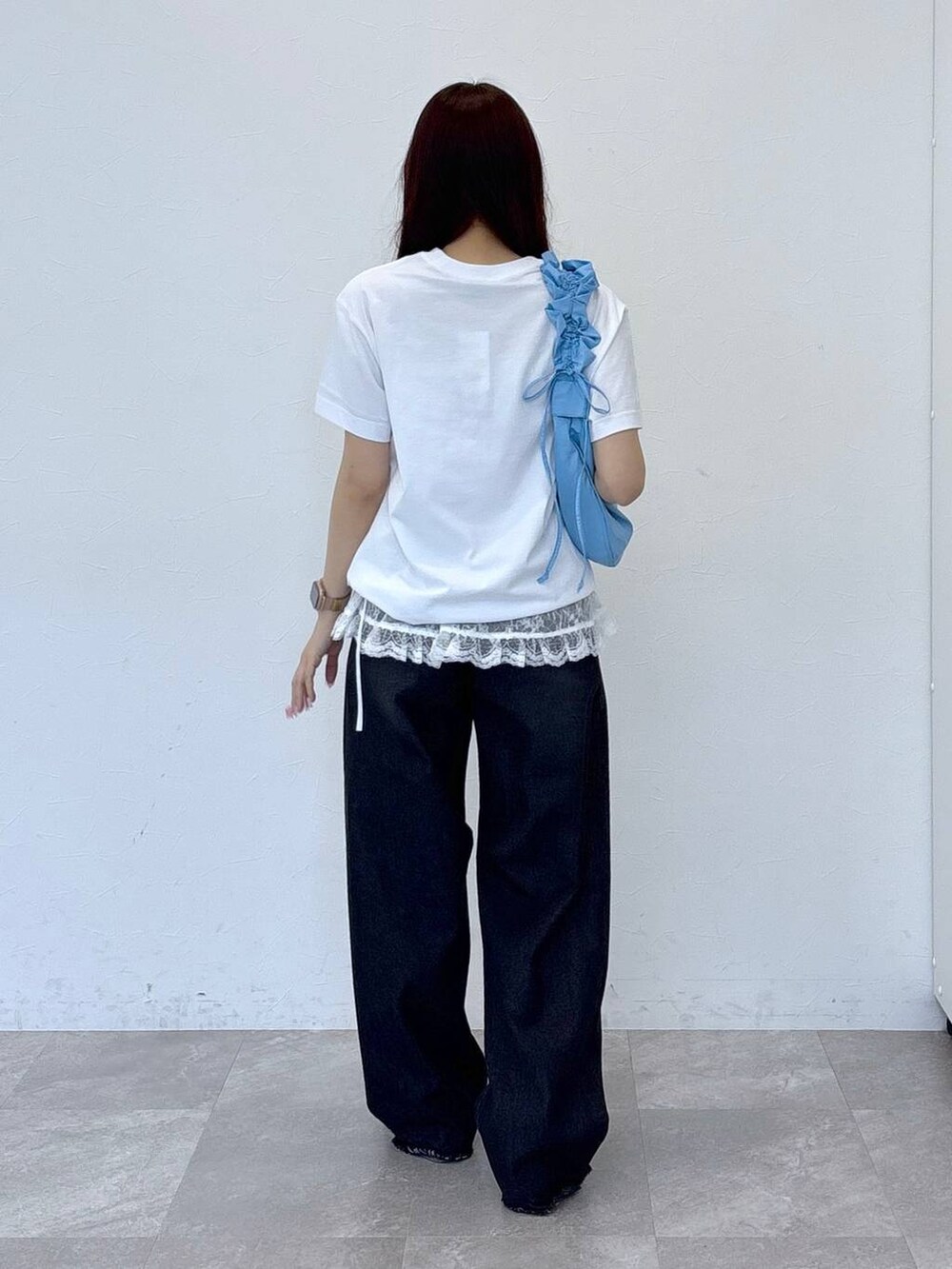 ブルー系のショルダーバッグ、ブラック系のデニムパンツ、ホワイト系のTシャツ/カットソーを着用したレディースの春コーディネートの4枚目の写真