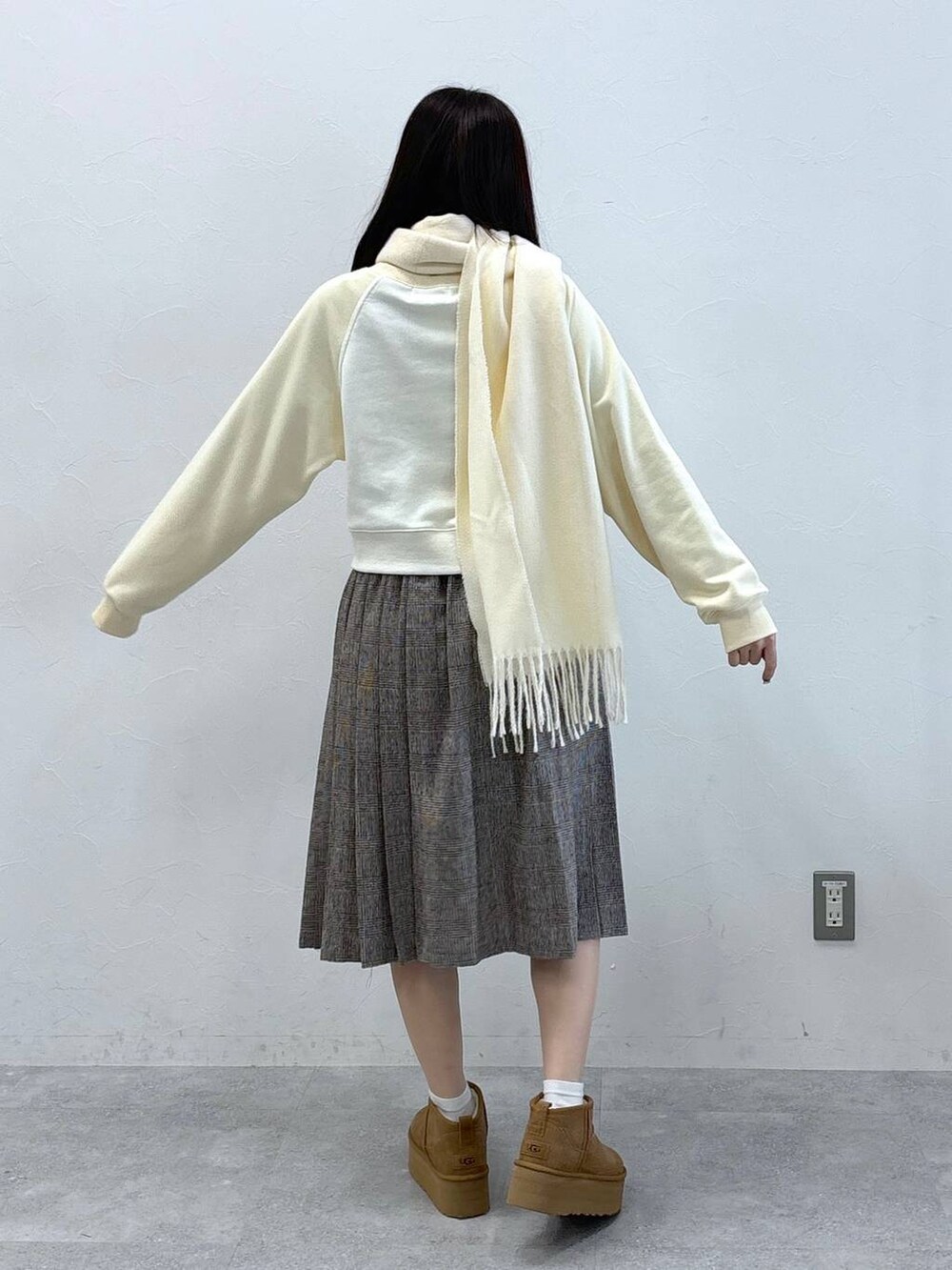 ブラウン系のスカート、ベージュ系のスウェット、ホワイト系のマフラーを着用したレディースの秋コーディネートの4枚目の写真