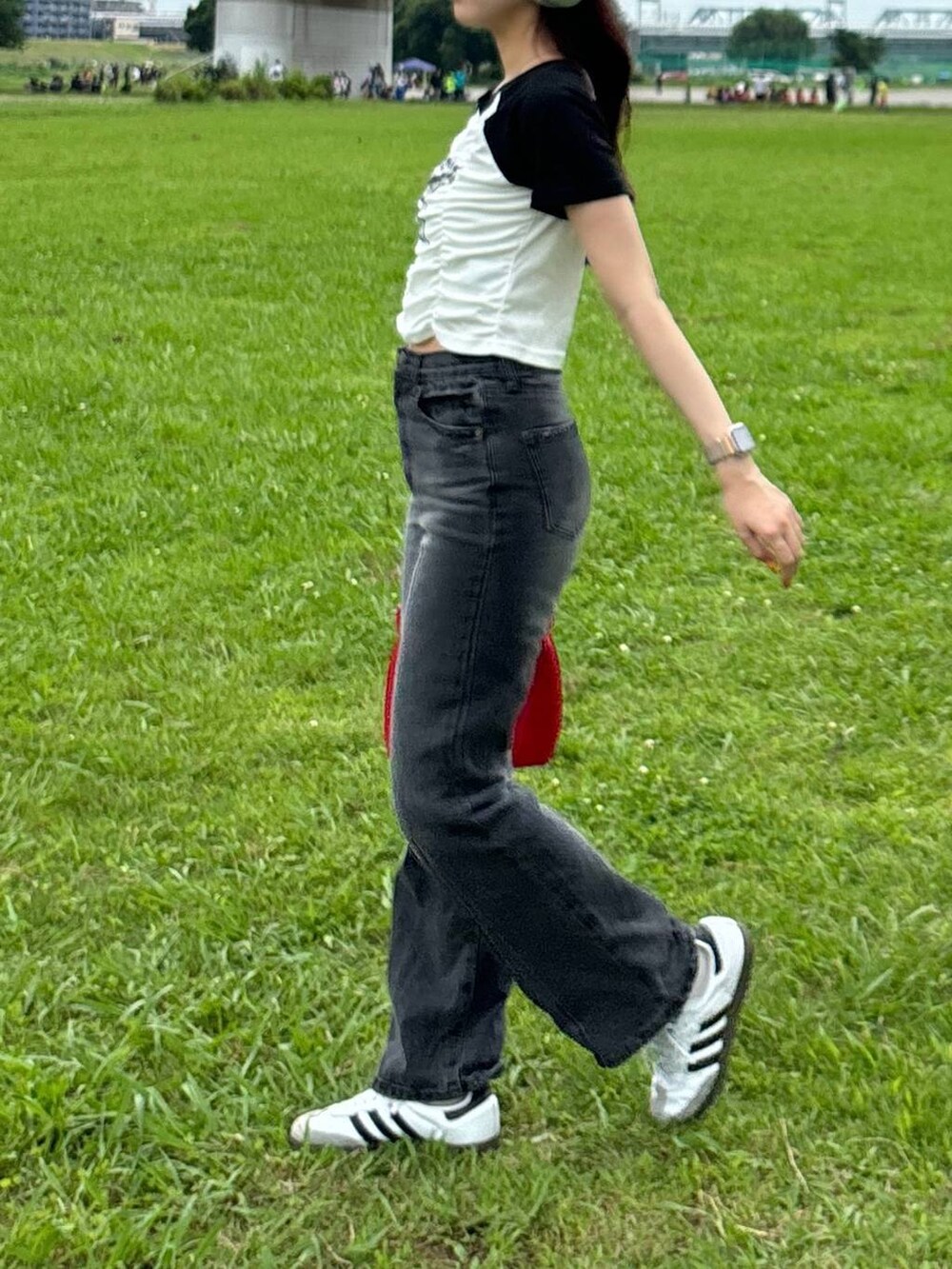 レッド系のハンドバッグ、ホワイト系のTシャツ/カットソーを着用したレディースの夏コーディネートの2枚目の写真