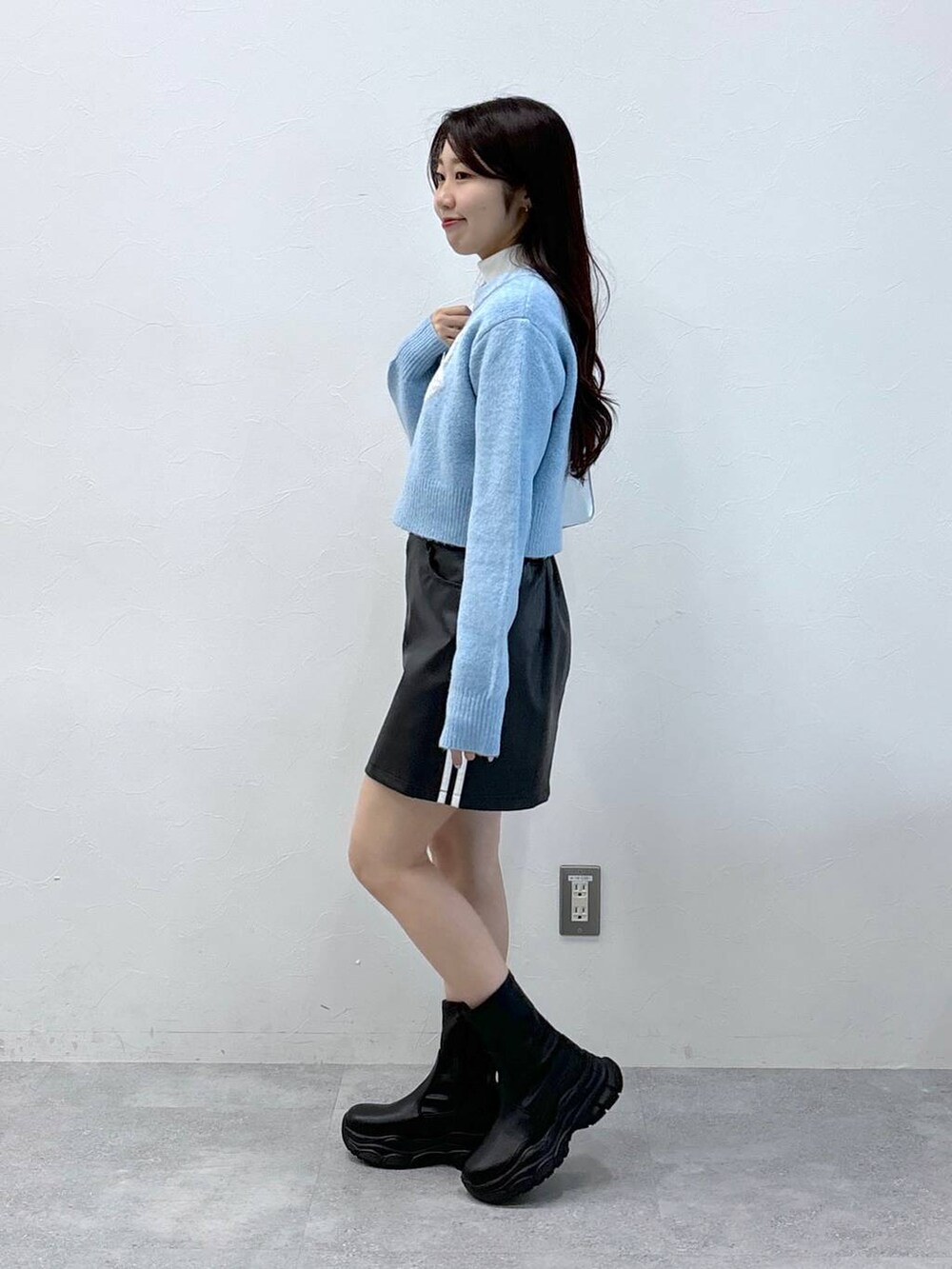 シルバー系のショルダーバッグ、ブルー系のニット/セーター、ブラック系のスカートを着用したレディースの秋コーディネートの3枚目の写真