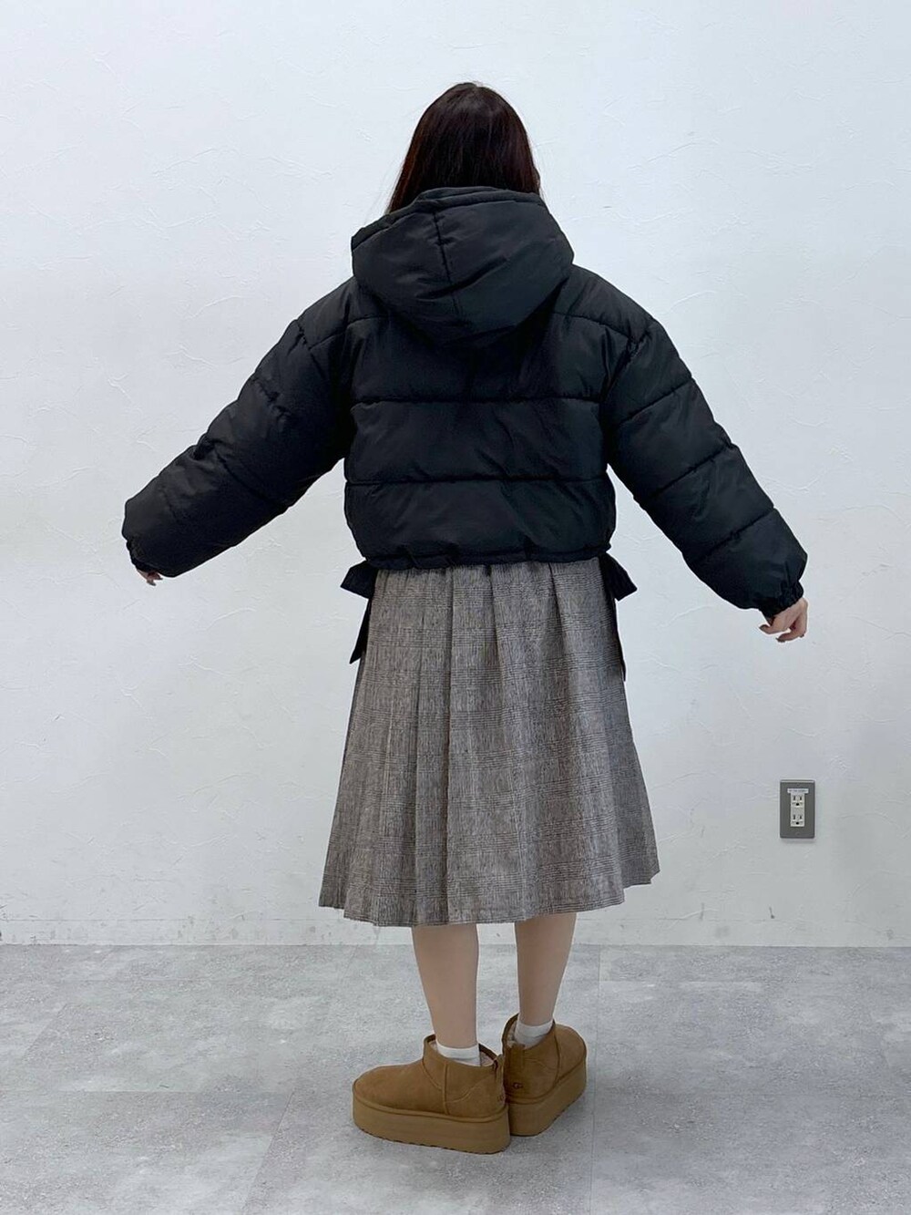 ブラック系のダウンジャケット/コート、ブラウン系のスカートを着用したレディースの秋コーディネートの5枚目の写真