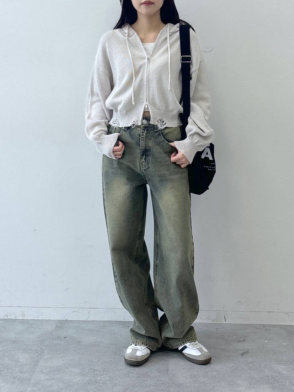 ブルー系のデニムパンツ、ブラック系のトートバッグを着用したレディースの春コーディネートの3枚目の写真