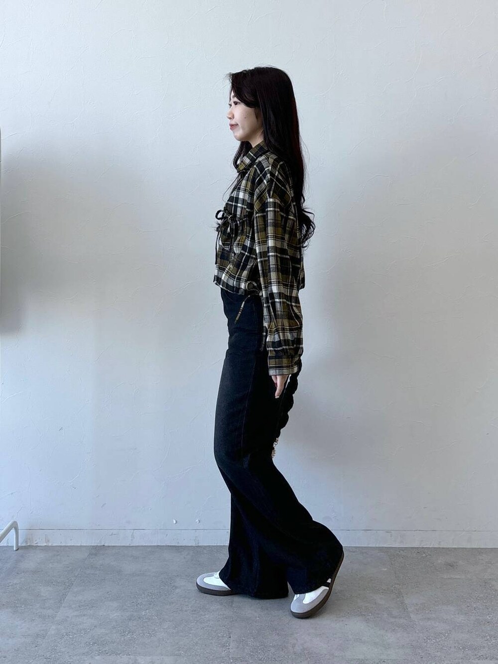 ブラック系のショルダーバッグ、ブラック系のデニムパンツ、イエロー系のシャツ/ブラウスを着用したレディースの冬コーディネートの3枚目の写真