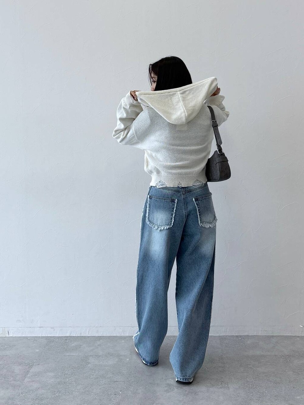 ブラック系のトートバッグ、ブラック系のTシャツ/カットソー、ブルー系のデニムパンツを着用したレディースの秋コーディネートの6枚目の写真