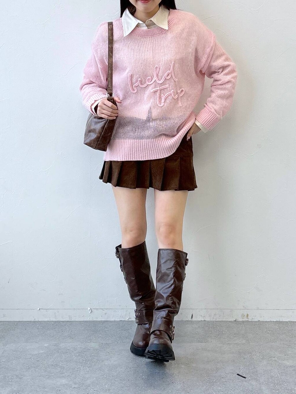 ブラウン系のブーツ、ブラウン系のスカート、ブラウン系のハンドバッグを着用したレディースの冬コーディネートの3枚目の写真