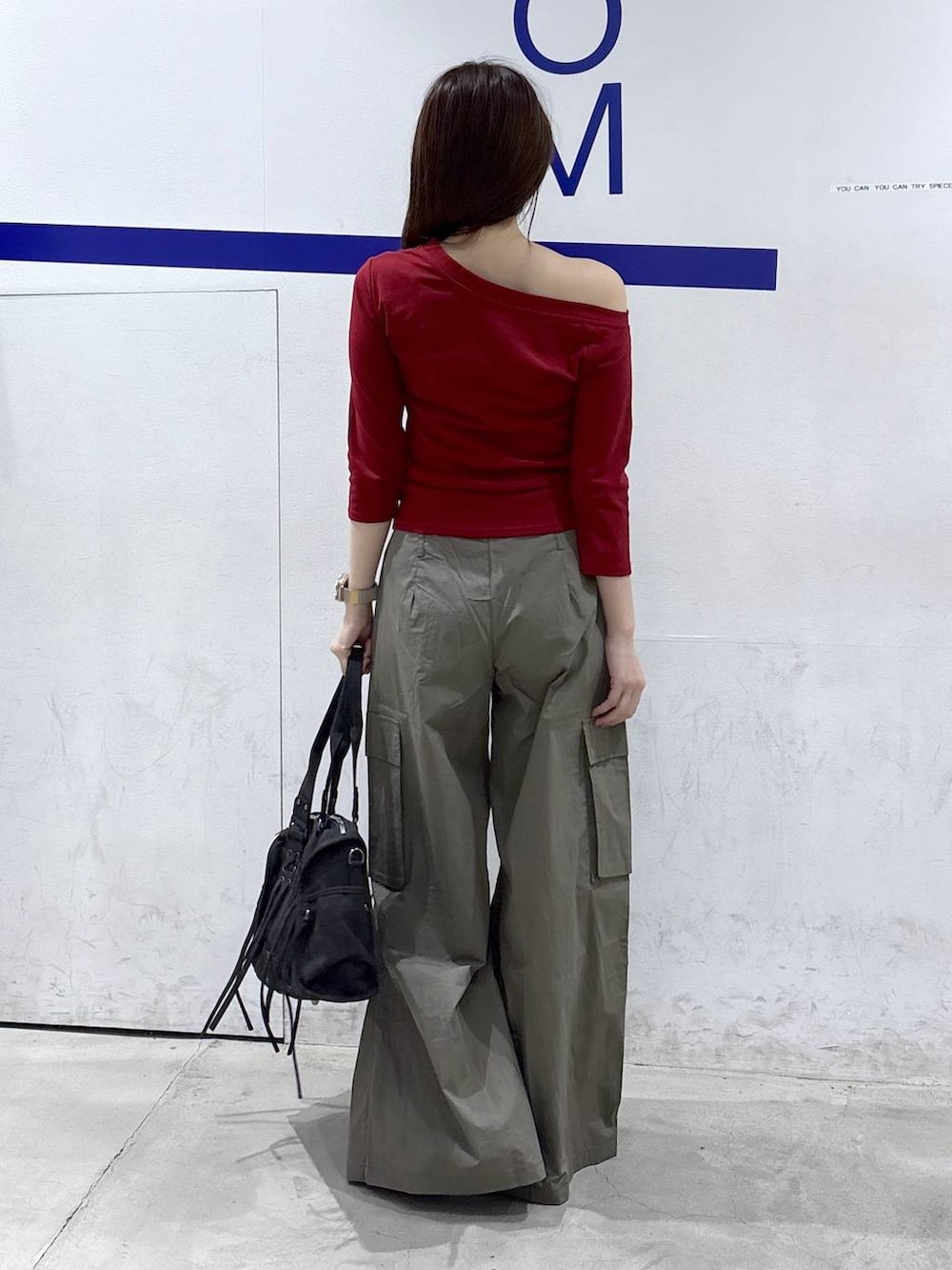 グリーン系のカーゴパンツ、ホワイト系のパンプス、ブラック系のショルダーバッグを着用したレディースの秋コーディネートの4枚目の写真