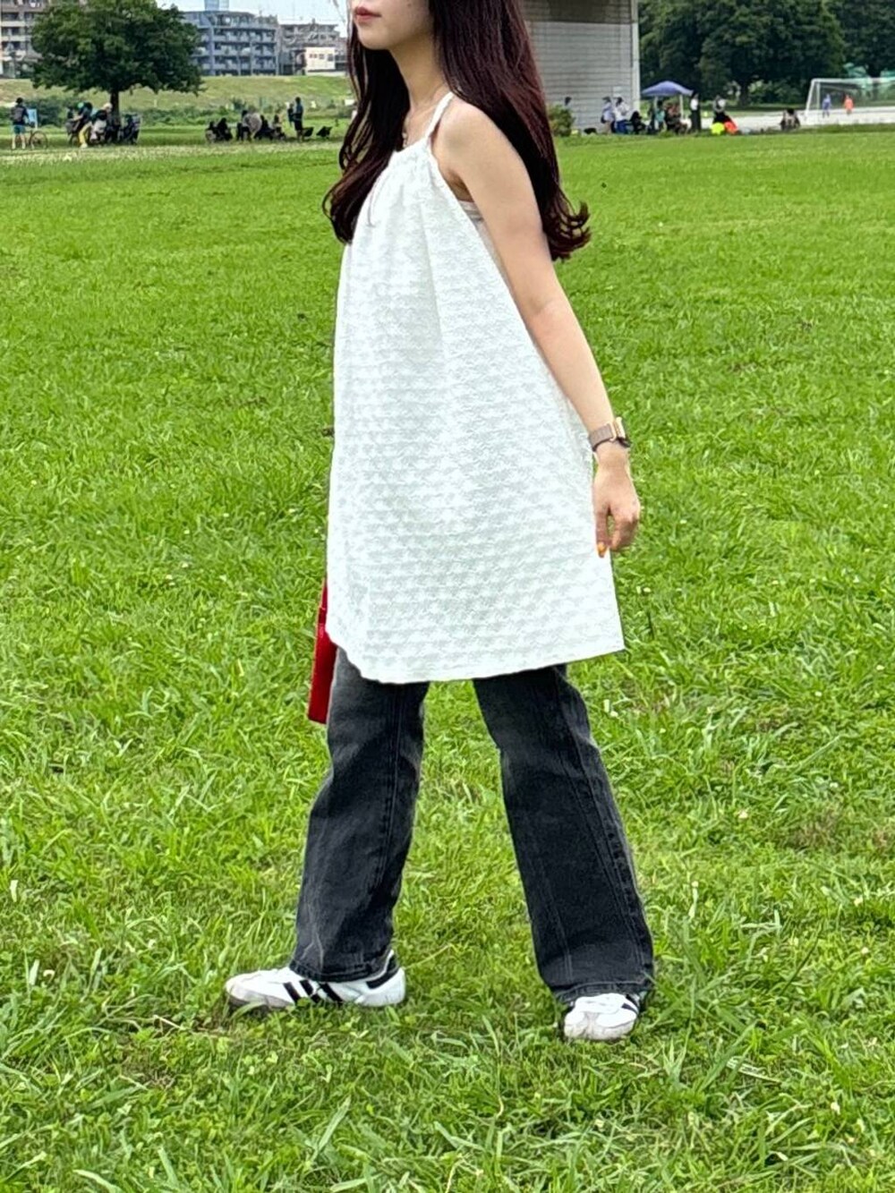 ホワイト系のワンピース、ベージュ系のチューブトップ、レッド系のハンドバッグを着用したレディースの夏コーディネートの3枚目の写真