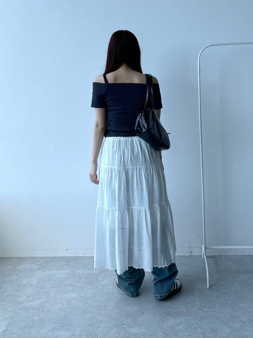 ブルー系のデニムパンツ、ベージュ系のスカート、グレー系のTシャツ/カットソーを着用したレディースの春コーディネートの4枚目の写真