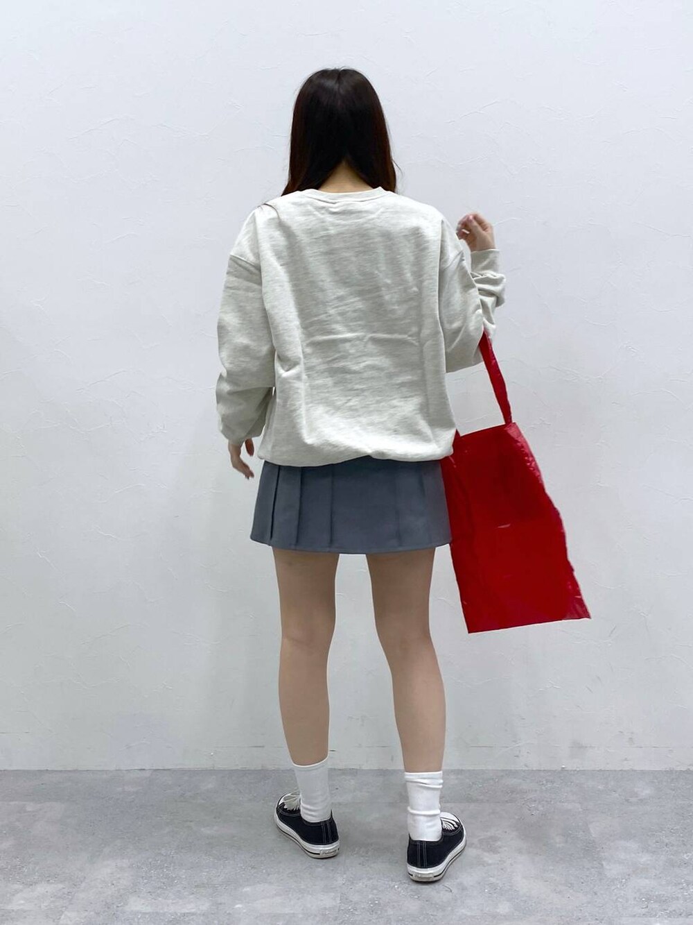 グレー系のスカート、レッド系のトートバッグ、ベージュ系のスウェットを着用したレディースの春コーディネートの4枚目の写真