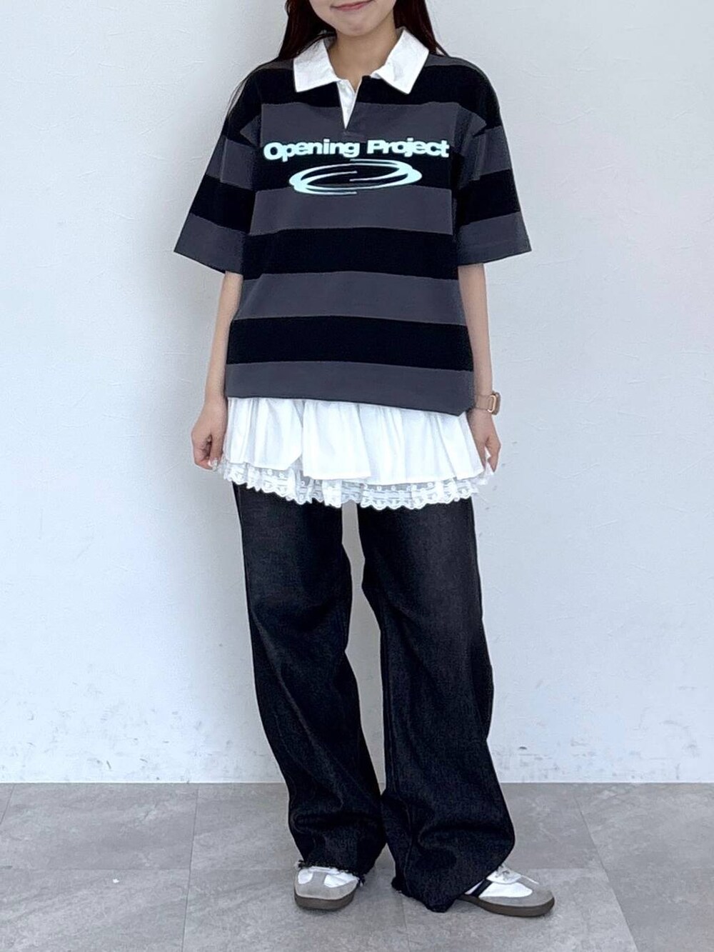 ブラック系のデニムパンツ、ベージュ系のスカート、グレー系のTシャツ/カットソーを着用したレディースの春コーディネートの2枚目の写真