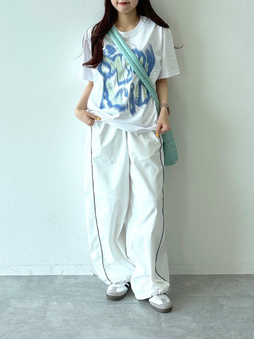グリーン系のショルダーバッグ、ホワイト系のその他パンツ、ホワイト系のTシャツ/カットソーを着用したレディースの夏コーディネートの2枚目の写真