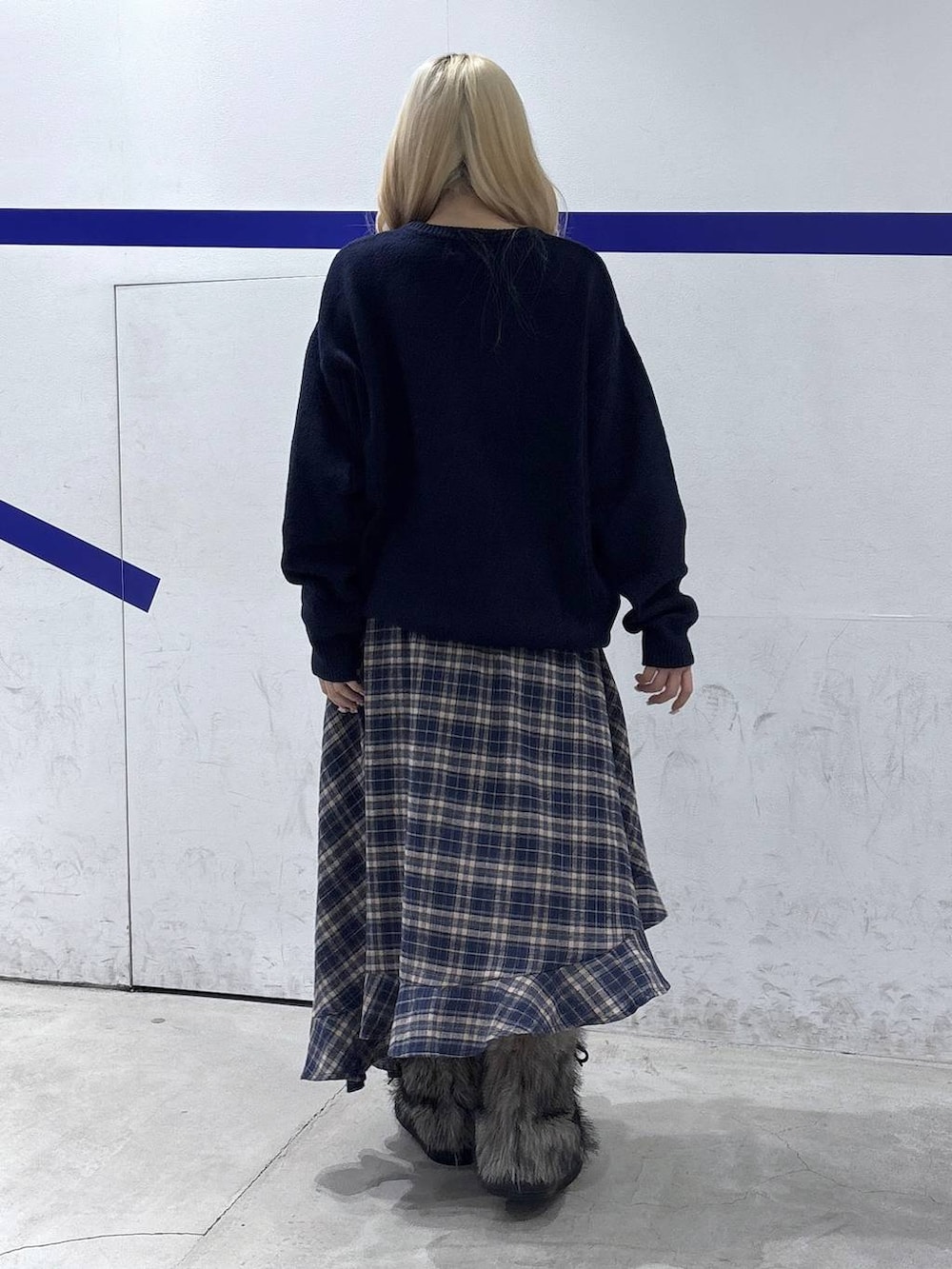 ブルー系のニット/セーター、ブルー系のスカート、グレー系のブーツを着用したレディースの秋コーディネートの4枚目の写真