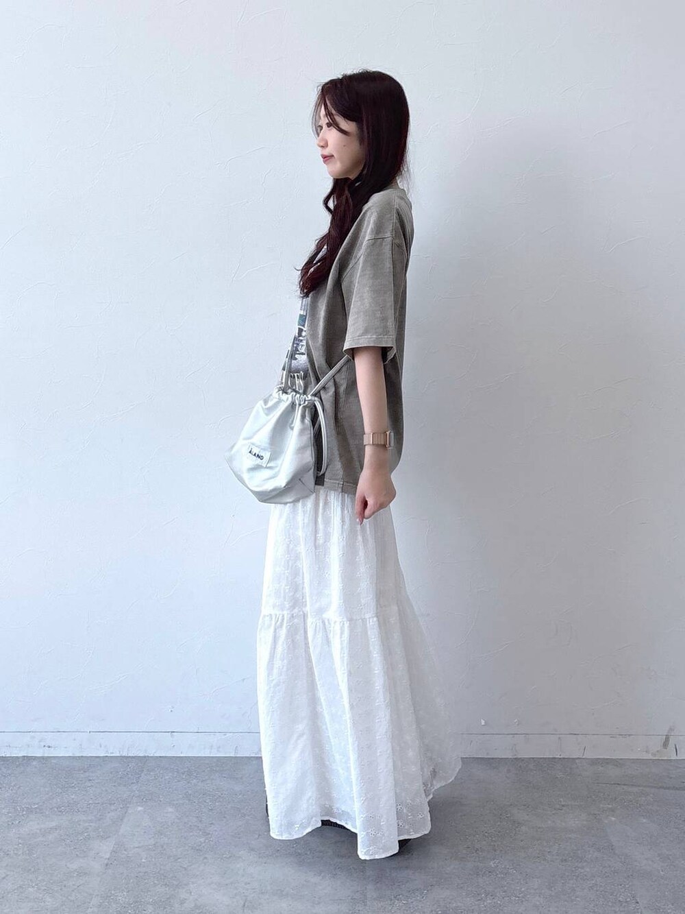 ホワイト系のスカート、シルバー系のショルダーバッグ、ベージュ系のTシャツ/カットソーを着用したレディースの春コーディネートの3枚目の写真