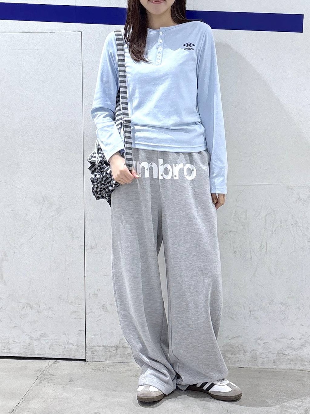 グレー系のスウェットパンツ、ブルー系のTシャツ/カットソー、グレー系のバックパック/リュックを着用したレディースの秋コーディネートの2枚目の写真