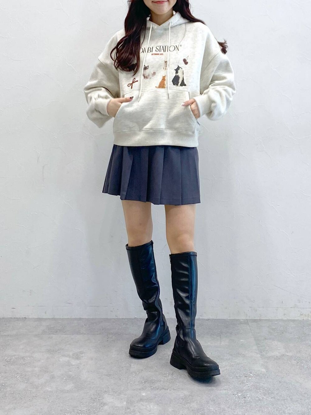 グレー系のスカート、ベージュ系のパーカーを着用したレディースの冬コーディネートの2枚目の写真