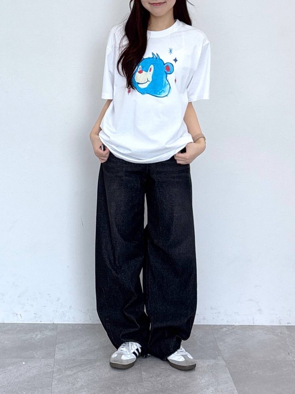 ブラック系のデニムパンツ、ホワイト系のTシャツ/カットソーを着用したレディースの春コーディネートの2枚目の写真