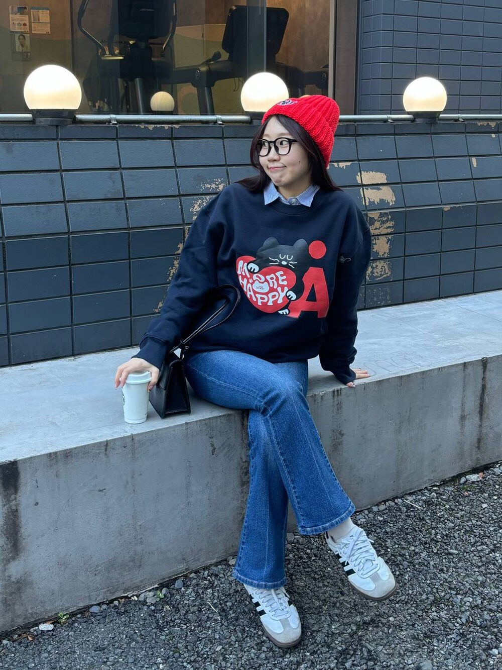 ブルー系のデニムパンツ、ブラック系のショルダーバッグ、ブルー系のスウェットを着用したレディースの冬コーディネートの6枚目の写真