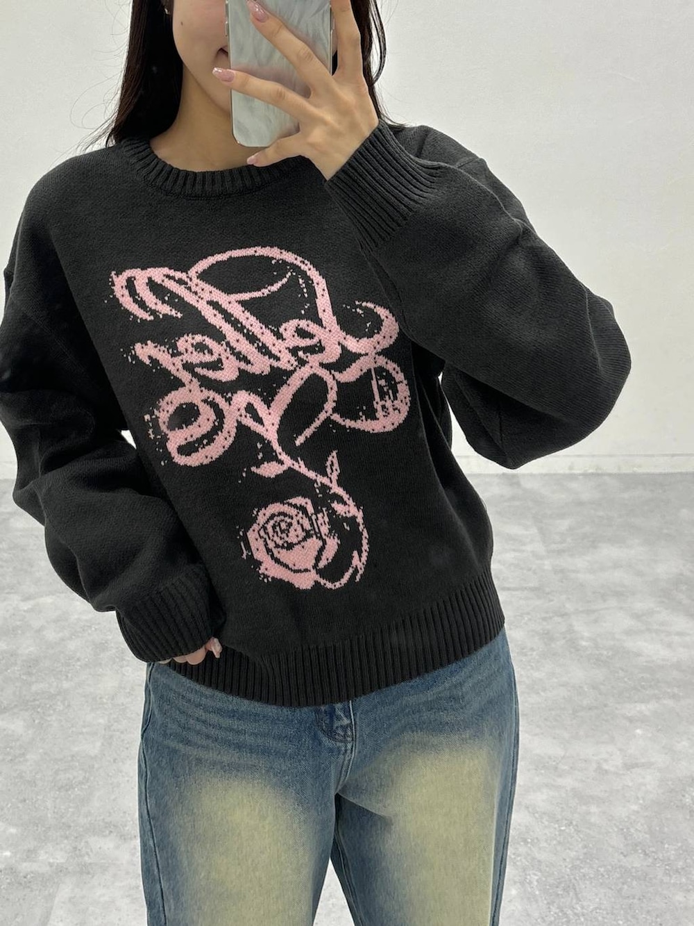 ブルー系のデニムパンツ、ホワイト系のショルダーバッグ、グレー系のニット/セーターを着用したレディースの秋コーディネートの2枚目の写真