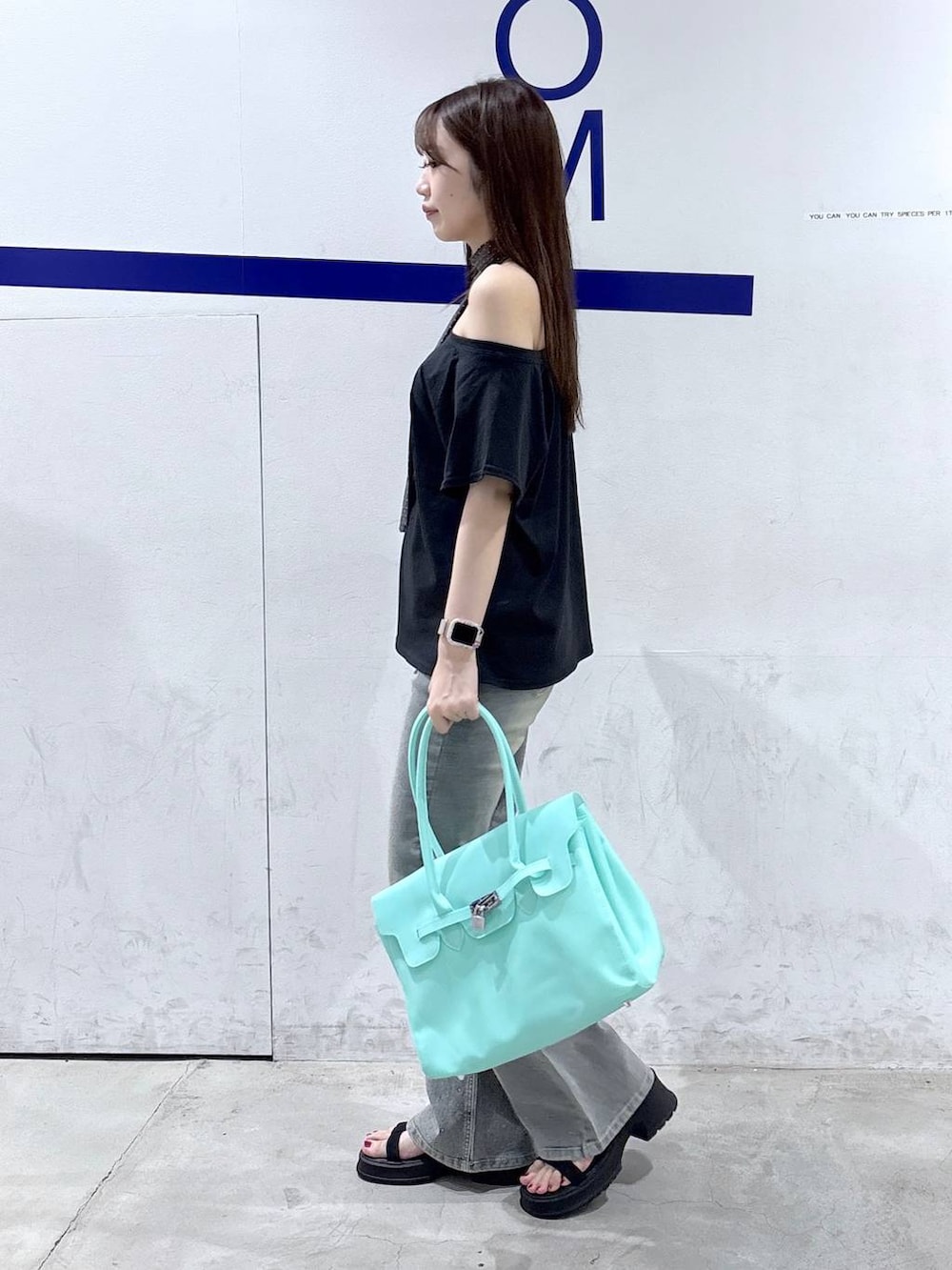 グリーン系のショルダーバッグ、ブラック系のサンダル、ブラック系のTシャツ/カットソーを着用したレディースの夏コーディネートの3枚目の写真