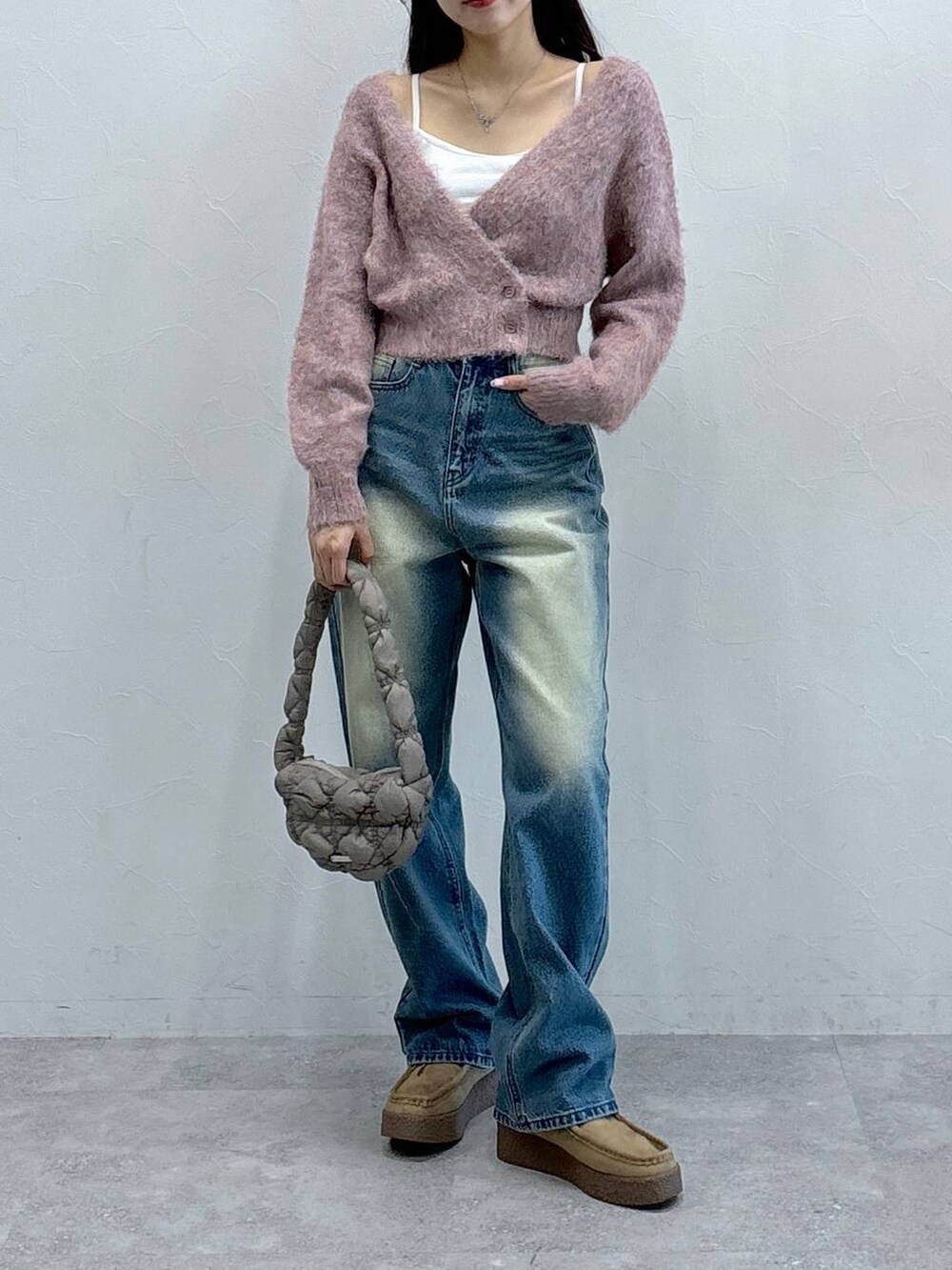 グレー系のショルダーバッグ、オレンジ系のカーディガン/ボレロ、ブルー系のデニムパンツを着用したレディースの秋コーディネートの2枚目の写真