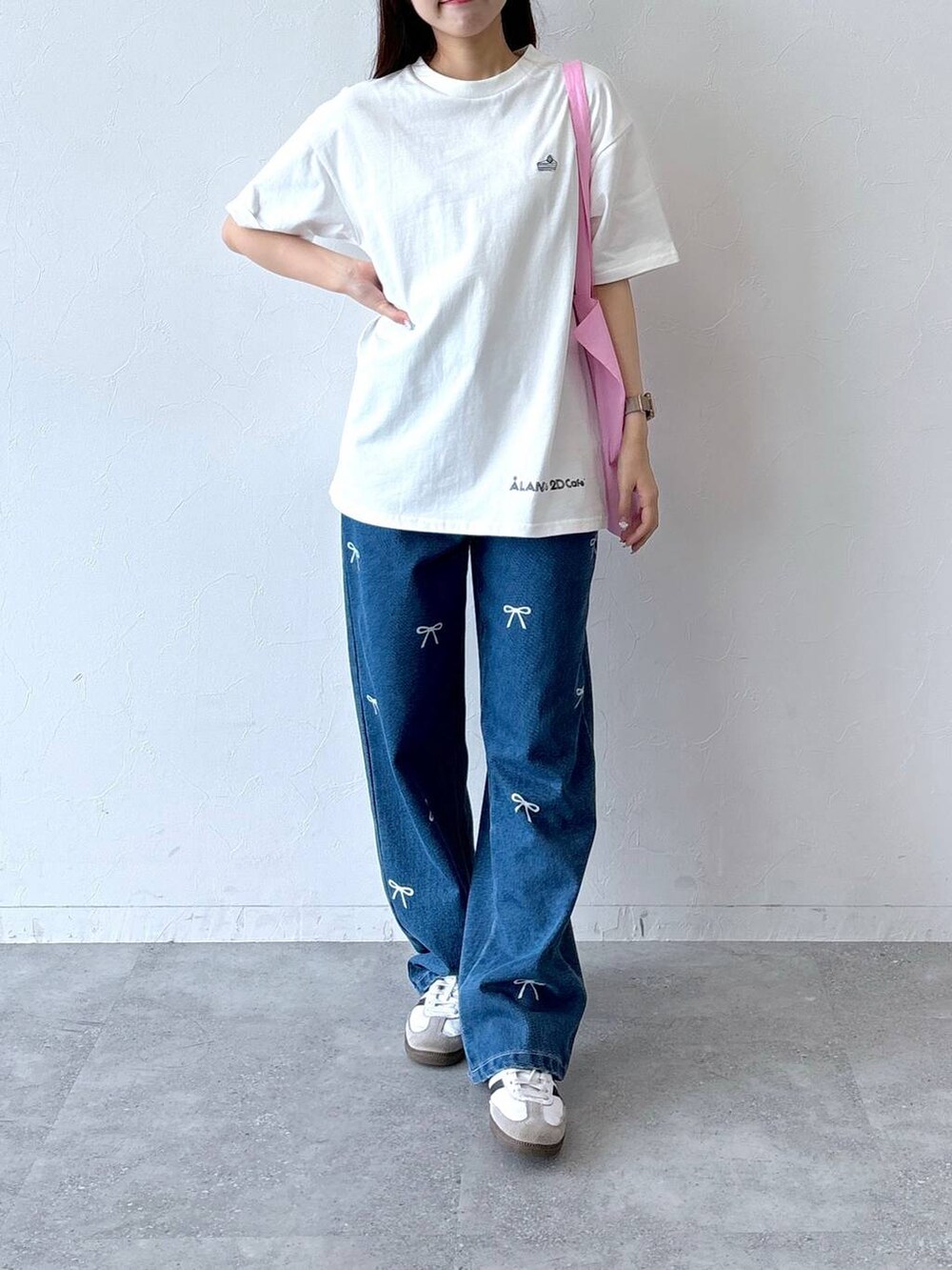 ブルー系のデニムパンツ、ホワイト系のTシャツ/カットソー、ピンク系のトートバッグを着用したレディースの夏コーディネートの2枚目の写真