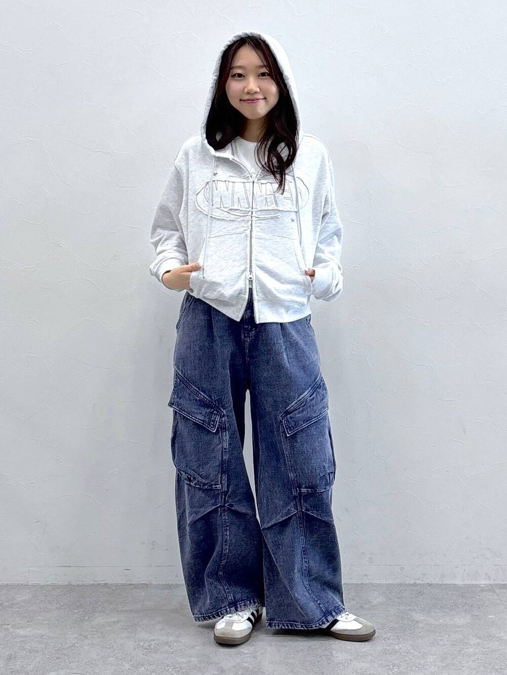 パープル系のカーゴパンツ、グレー系のパーカーを着用したレディースの春コーディネートの3枚目の写真