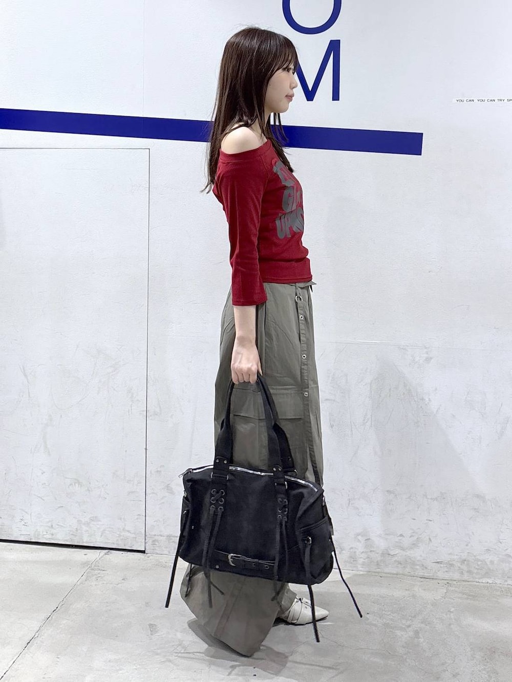 グリーン系のカーゴパンツ、ホワイト系のパンプス、ブラック系のショルダーバッグを着用したレディースの秋コーディネートの3枚目の写真