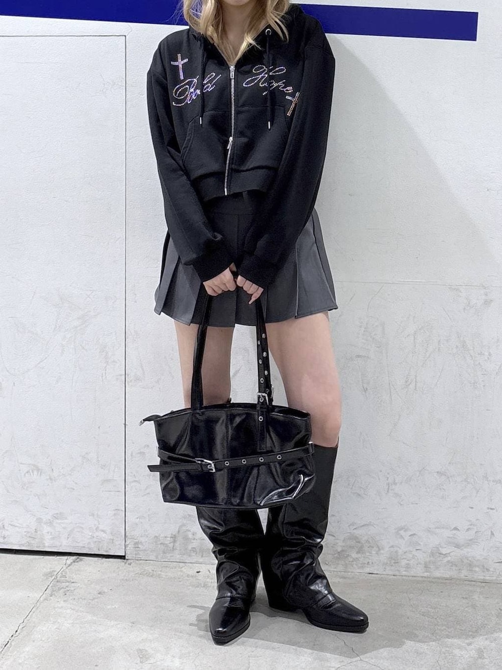 ブラック系のパーカー、ブラック系のブーツ、ブラック系のショルダーバッグを着用したレディースの冬コーディネートの2枚目の写真