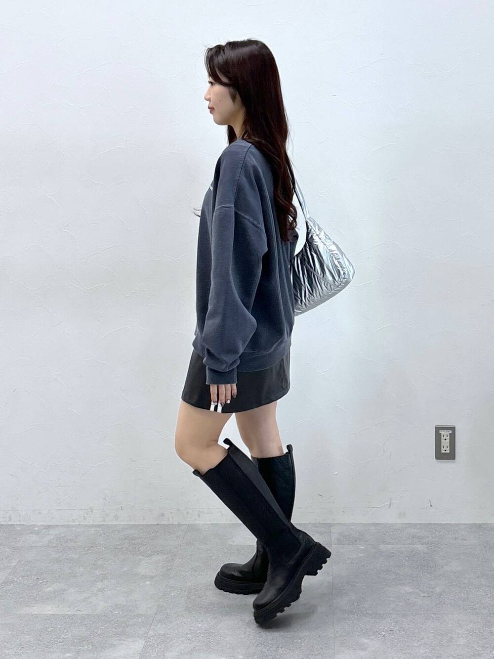 その他のショルダーバッグ、ブラック系のスカート、ブラック系のブーツを着用したレディースの冬コーディネートの3枚目の写真