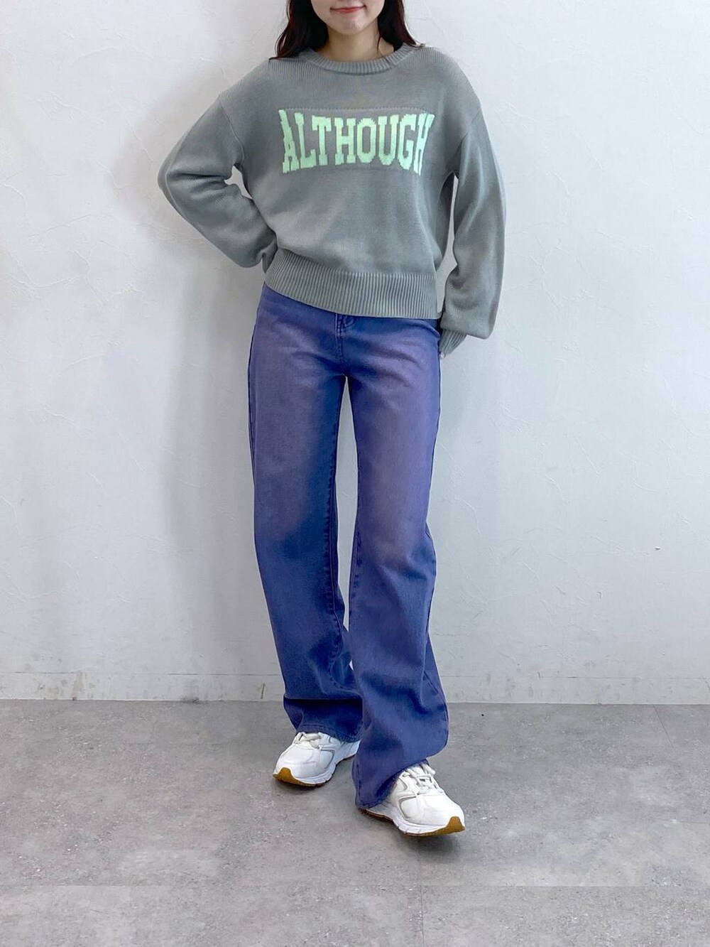 パープル系のデニムパンツ、グレー系のニット/セーターを着用したレディースの冬コーディネートの3枚目の写真