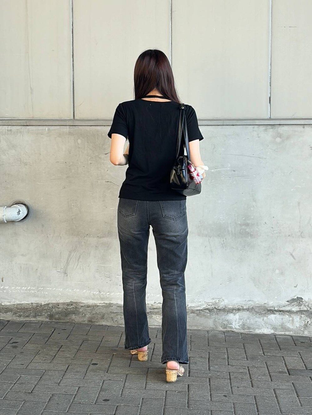 ブラック系のハンドバッグ、ブラック系のTシャツ/カットソーを着用したレディースの夏コーディネートの3枚目の写真