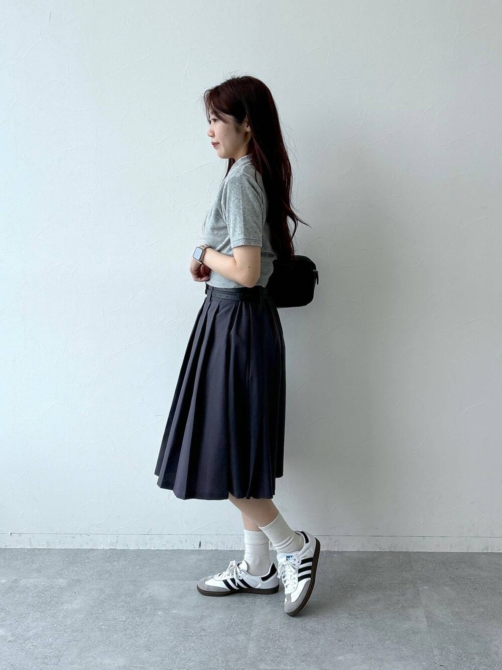 ブラック系のハンドバッグ、グレー系のスカート、グレー系のTシャツ/カットソーを着用したレディースの夏コーディネートの3枚目の写真