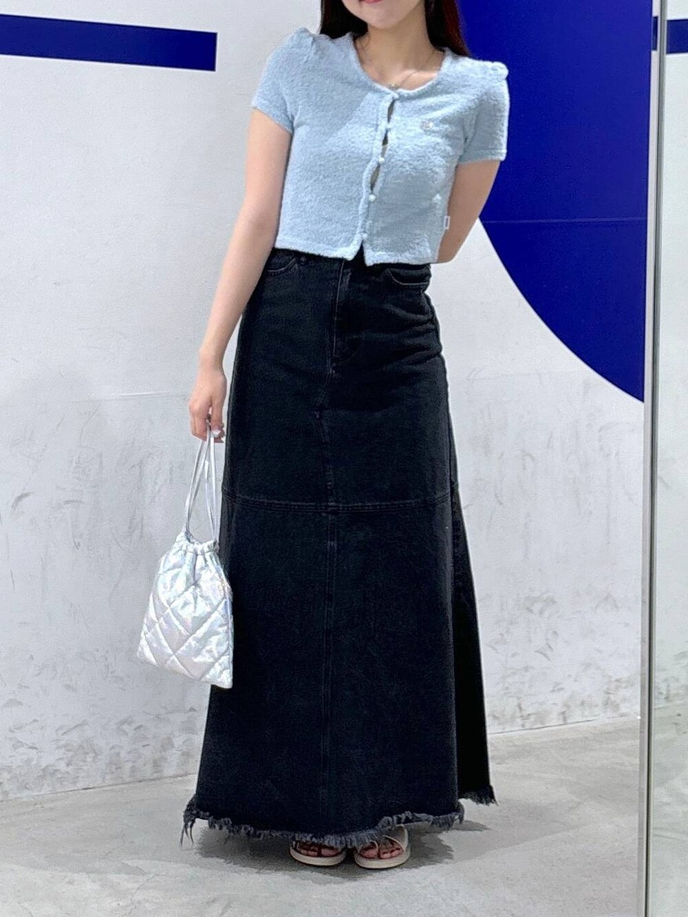 ブラック系のデニムスカート、シルバー系のショルダーバッグ、ブルー系のカーディガン/ボレロを着用したレディースの夏コーディネートの3枚目の写真