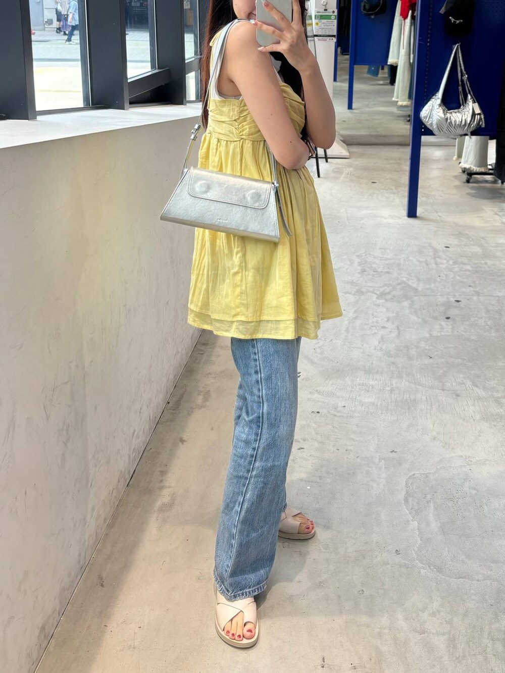 イエロー系のキャミソール、その他のショルダーバッグを着用したレディースの夏コーディネートの2枚目の写真