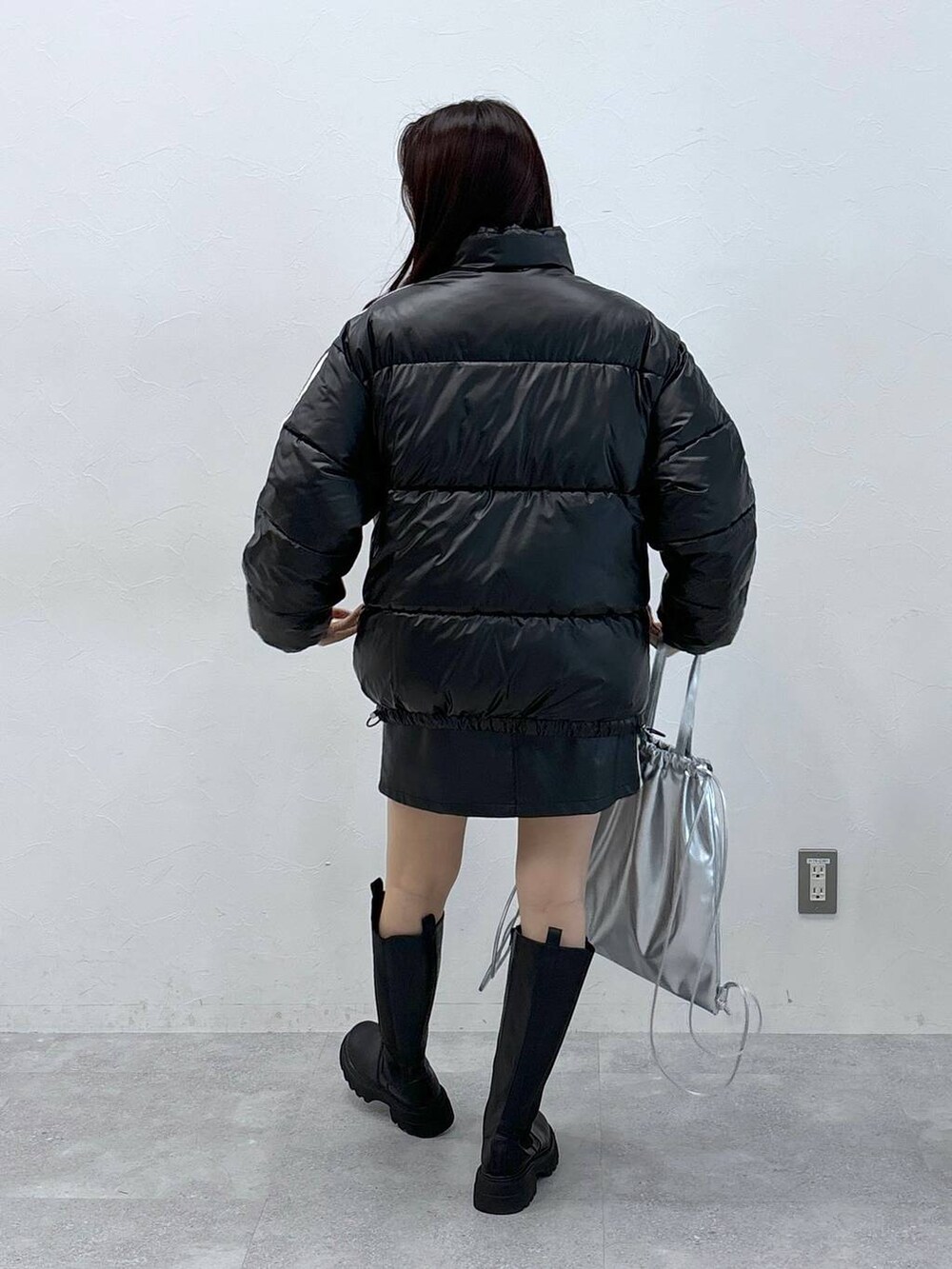 ブラック系のスカート、ブラック系のダウンジャケット/コート、ブラック系のブーツを着用したレディースの秋コーディネートの5枚目の写真