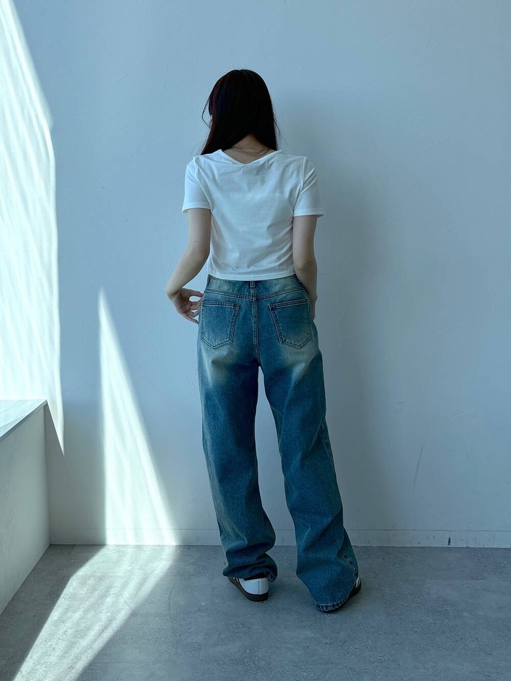 ホワイト系のTシャツ/カットソー、ブルー系のデニムパンツを着用したレディースの春コーディネートの4枚目の写真