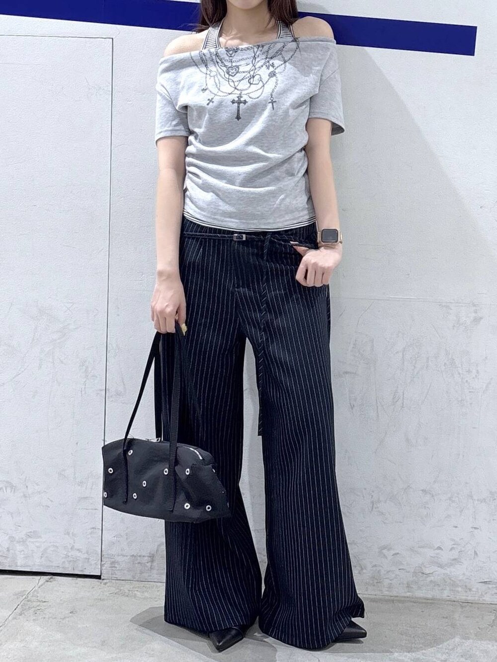 ブラック系のパンプス、グレー系のTシャツ/カットソー、ブラック系のショルダーバッグを着用したレディースの春コーディネートの2枚目の写真