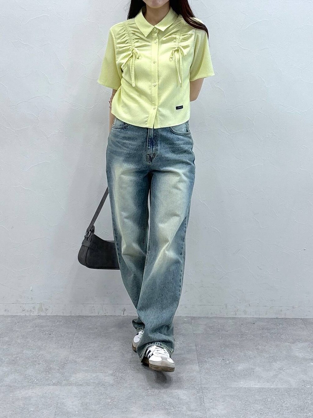 ブルー系のデニムパンツ、ブラック系のトートバッグ、グリーン系のシャツ/ブラウスを着用したレディースの夏コーディネートの2枚目の写真