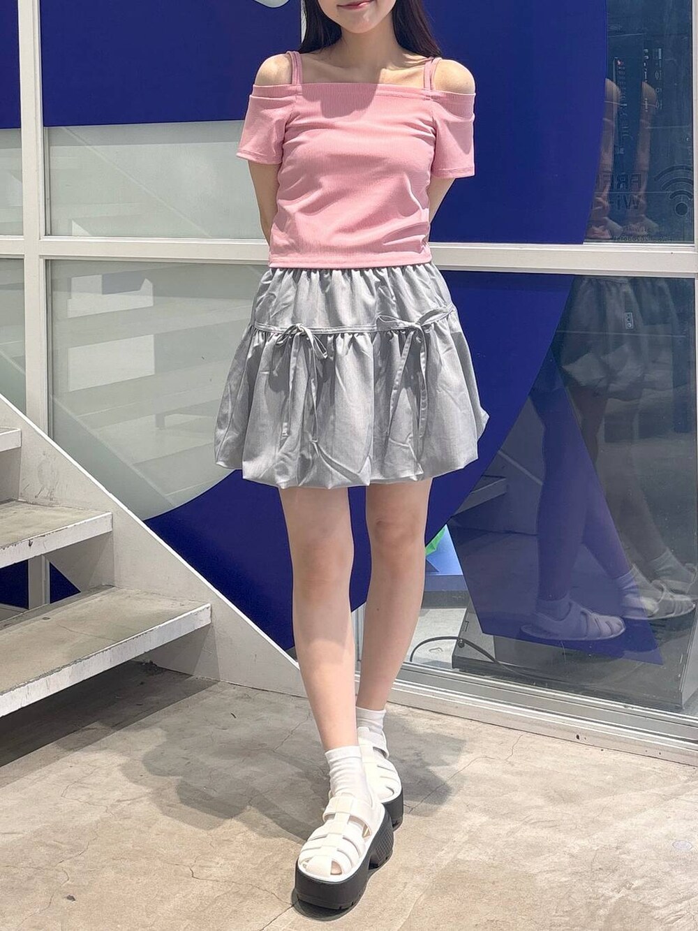 その他のサンダル、ピンク系のTシャツ/カットソー、グレー系のスカートを着用したレディースの春コーディネートの2枚目の写真