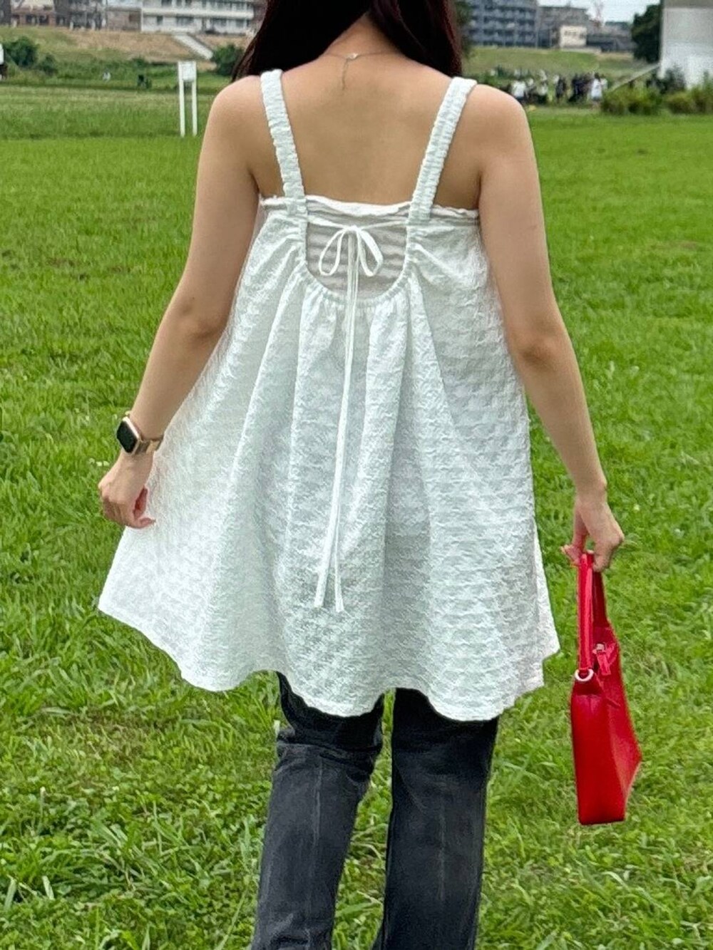 ホワイト系のワンピース、ベージュ系のチューブトップ、レッド系のハンドバッグを着用したレディースの夏コーディネートの6枚目の写真