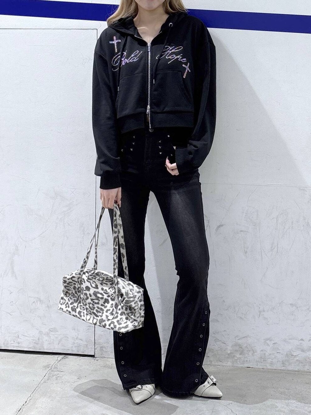 ホワイト系のパンプス、ブラック系のデニムパンツ、ホワイト系のショルダーバッグを着用したレディースの冬コーディネートの2枚目の写真