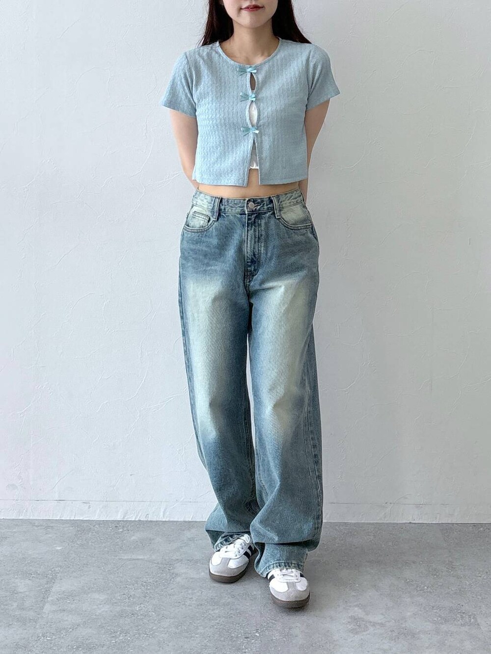 ブルー系のデニムパンツ、ベージュ系のチューブトップ、ブルー系のTシャツ/カットソーを着用したレディースの春コーディネートの2枚目の写真