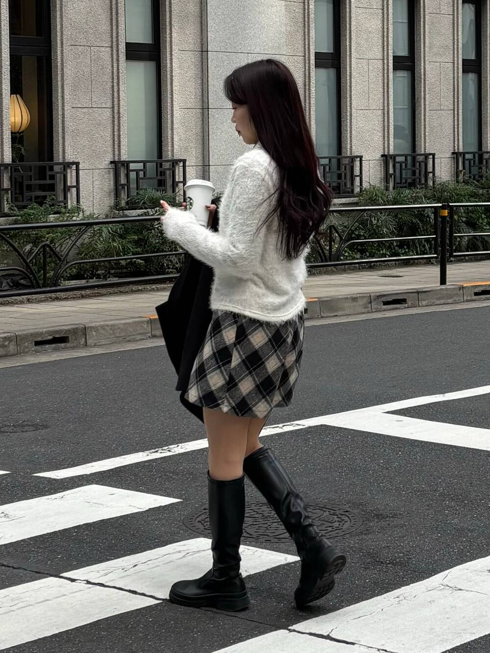 ブラック系のスカート、ホワイト系のニット/セーターを着用したレディースの冬コーディネートの3枚目の写真