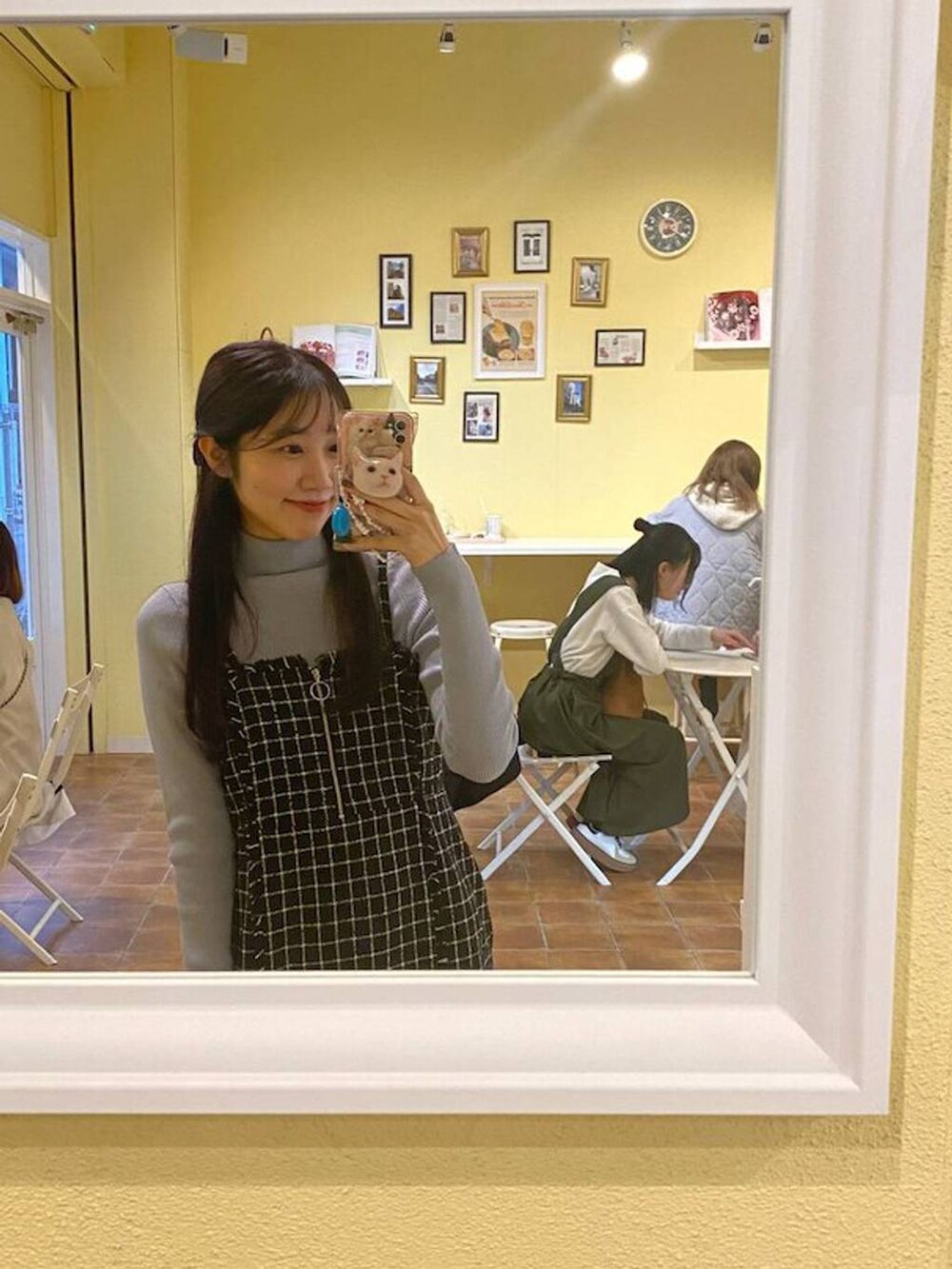 ブラック系のショルダーバッグ、ブルー系のニット/セーター、ブラック系のワンピースを着用したレディースの冬コーディネートの3枚目の写真