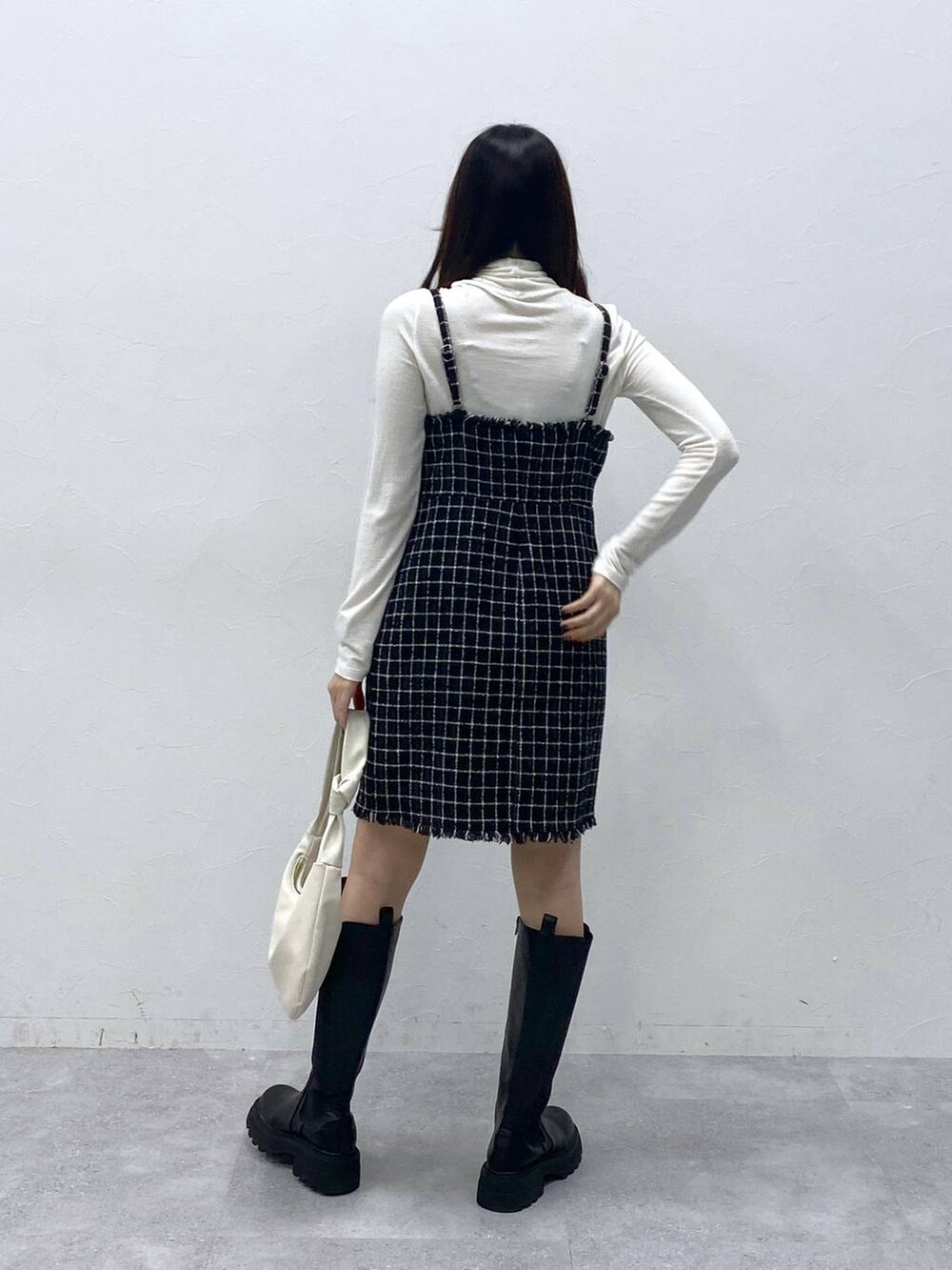 ブラック系のブーツ、ベージュ系のTシャツ/カットソー、ブラック系のワンピースを着用したレディースの冬コーディネートの4枚目の写真