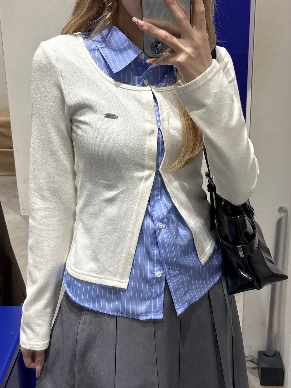 ホワイト系のパンプス、ブラック系のショルダーバッグ、ベージュ系のカーディガン/ボレロを着用したレディースの冬コーディネートの6枚目の写真