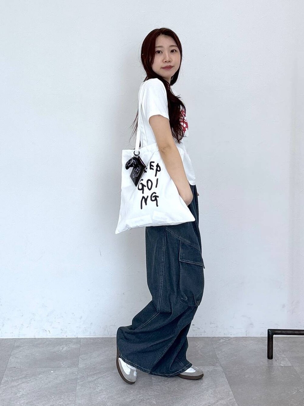 ブルー系のカーゴパンツ、その他のトートバッグ、ホワイト系のTシャツ/カットソーを着用したレディースの春コーディネートの3枚目の写真